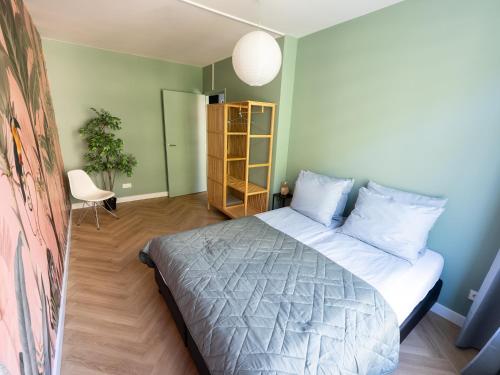 a bedroom with a bed and a green wall at Rotterdam's coolest apartment in Rotterdam