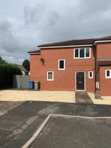 un bâtiment en briques avec un parking en face de celui-ci dans l'établissement The Glebe DN22, à Retford