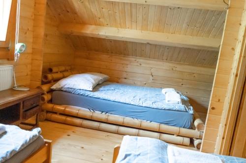 a room with a bed in a log cabin at Domek Słoneczny Całoroczny 800m od Parku Wodnego Suntago Ranczo Gold Mania in Żyrardów