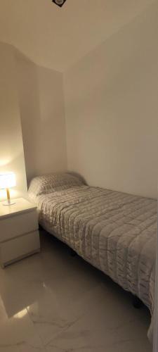 a small bedroom with a bed and a night stand at Seaview By D. in Torrevieja