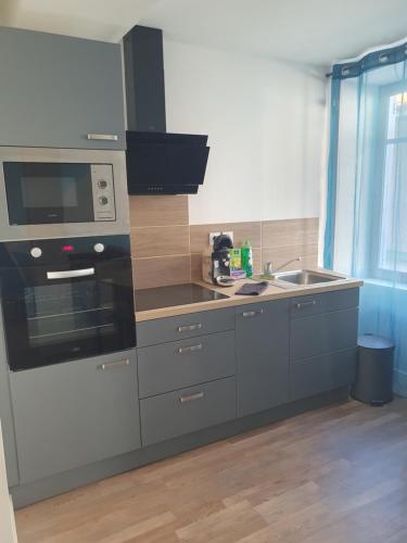 La cuisine est équipée d'un évier et de plaques de cuisson. dans l'établissement Jolie T3 avec terrasse, à Carcassonne