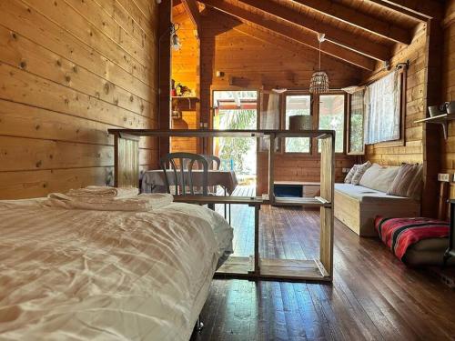 a bedroom with a bed in a wooden cabin at הקטלב- בקתה בין קטלב אחד ואלונים in Abirim