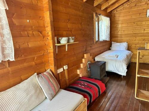 Habitación con 2 camas en una cabaña de madera en הקטלב- בקתה בין קטלב אחד ואלונים, en Abirim