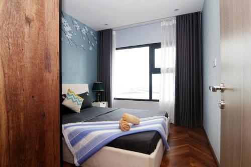 a bedroom with a bed with a teddy bear on it at VINHOME OCEAN PARK GIA LÂM in Hanoi