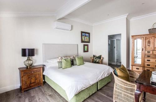 a bedroom with a white bed and a table and chairs at Thyme Wellness Spa and Guesthouse in Cape Town
