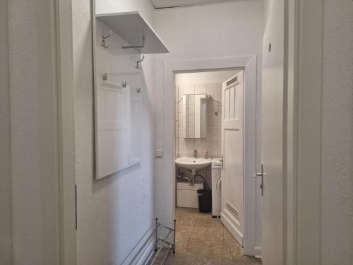 a white bathroom with a sink and a mirror at Studio Apartment 20 in Essen