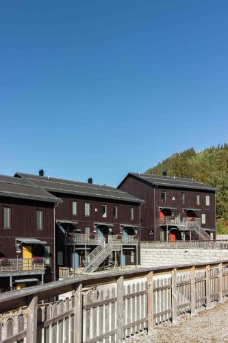 a group of buildings with a fence in front of them at Funäs Ski Lodge in Funäsdalen