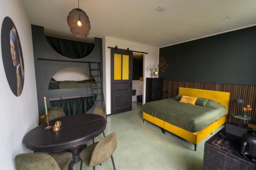 1 dormitorio con 1 cama, mesa y sillas en De Kerck - bijzonder overnachten en Middelburg