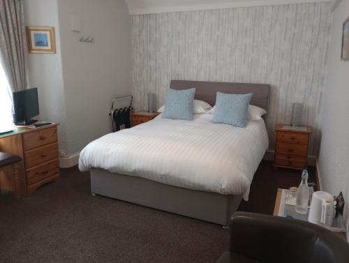 a bedroom with a large bed with blue pillows at Hazeldene Guest House in Bowness-on-Windermere