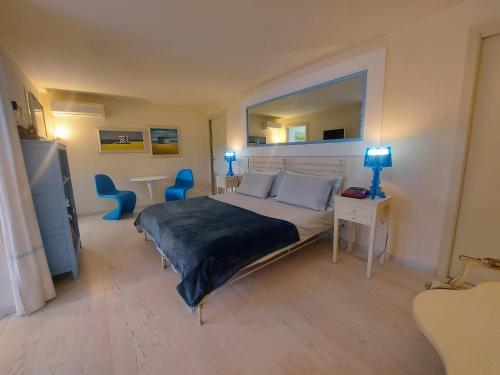トッリ・デル・ベーナコにあるMINI DI LUSSO CON PISCINAのベッドルーム1室(ベッド1台、青い椅子2脚付)