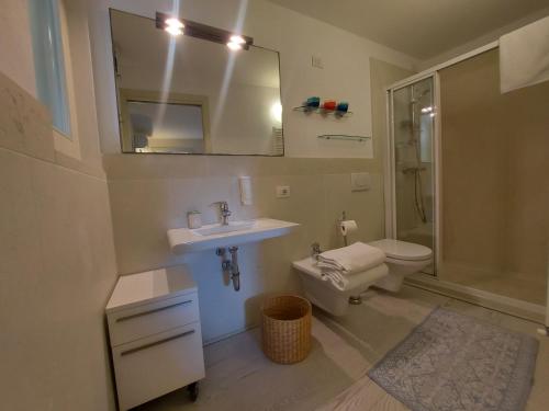トッリ・デル・ベーナコにあるMINI DI LUSSO CON PISCINAの洗面台、トイレ、鏡のあるバスルーム