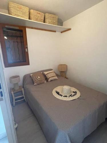 une chambre avec un lit avec un chapeau dessus dans l'établissement La Casita ,Appartement face à l’étang, au Barcarès