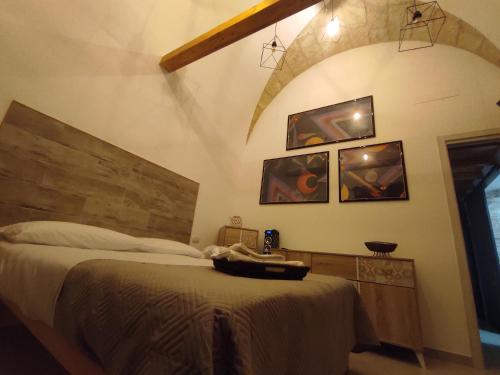 Schlafzimmer mit einem großen Bett mit einem Kopfteil aus Holz in der Unterkunft Dimora Kettino in Mola di Bari