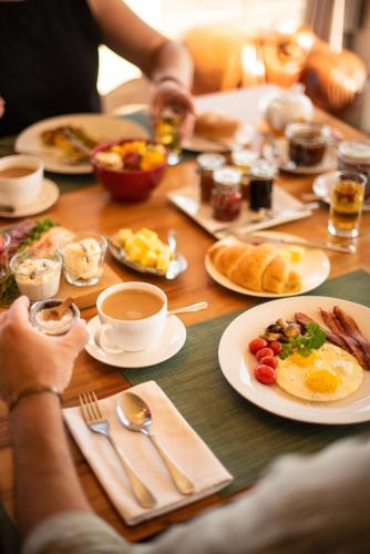a table with plates of breakfast food on it at Whalesong Lodge in Gansbaai