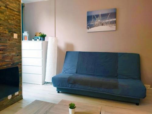 un salon avec un canapé bleu dans une pièce dans l'établissement Le Cosy Babylone, à La Grande Motte
