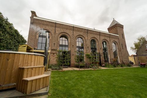 a large brick building with a green yard at De Kerck - bijzonder overnachten in Middelburg