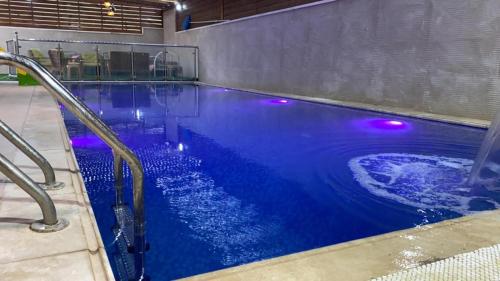 傑里科的住宿－alzain villas - فلل الزين اريحا，蓝色水和紫色灯的游泳池