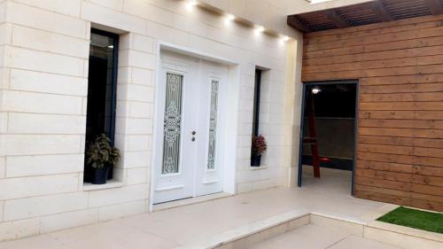 a white door on the side of a building at alzain villas - فلل الزين اريحا in Jericho