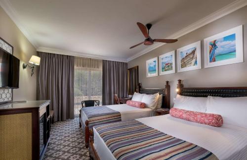 a hotel room with two beds and a television at Southern Sun Maputo in Maputo