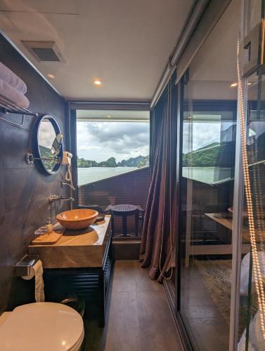 a bathroom with a sink and a toilet and a window at Scarlet Pearl Cruises - Wonder On Lan Ha Bay in Ha Long