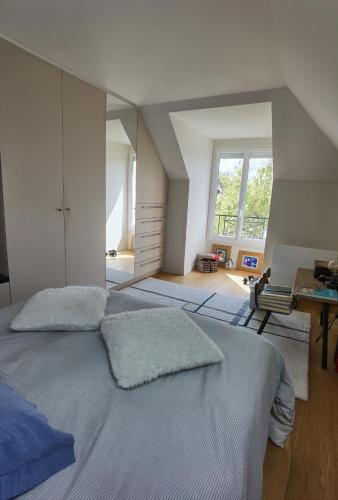 een grote slaapkamer met 2 bedden en een bureau bij 2 chambres dans maison familiale jardin et spa in Noisy-le-Roi