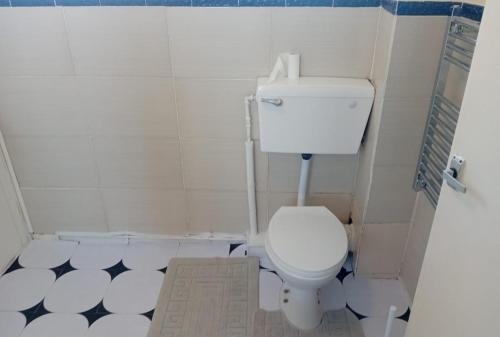 a bathroom with a white toilet and a black and white tiles at Fresher Space Home Stay in Walsall