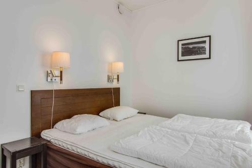 a bedroom with a bed with white sheets and two lamps at Funäs Ski Lodge in Funäsdalen