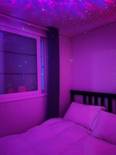 - une chambre violette avec un lit et une fenêtre dans l'établissement Stunning Luxury Apartment, à Séoul