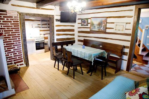 a dining room with a table and chairs and a kitchen at Agroturystyka Dyrdówka in Byszyce