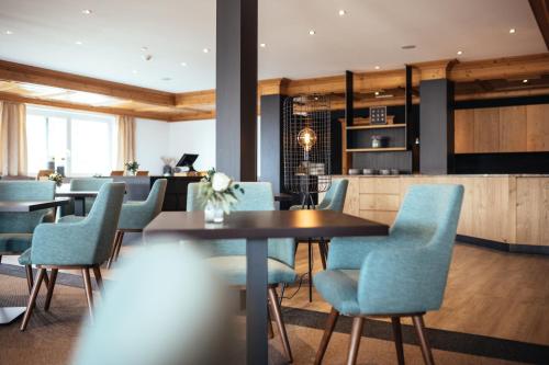 a dining room with blue chairs and a table at Hilburger Hotel in Schenna