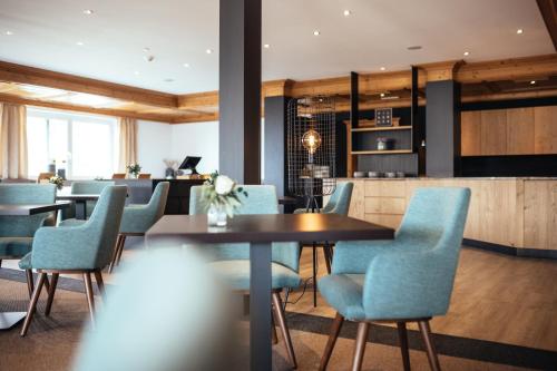 una sala da pranzo con sedie blu e tavolo di Hilburger Hotel a Scena