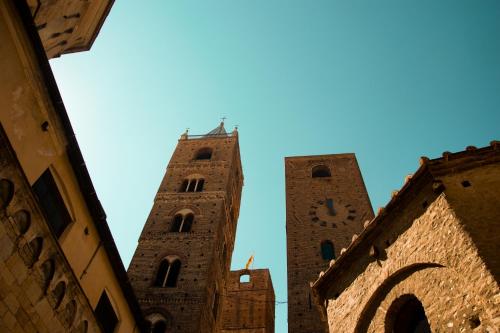 two tall towers with a clock on a building at Villa Essenza - Rooms and Breakfast in Albenga