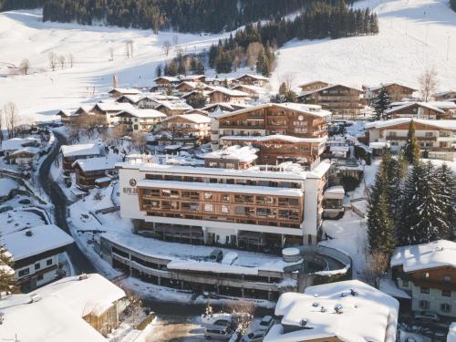a town covered in snow with buildings at Alpin Juwel - Bio und Lifestylehotel in Saalbach Hinterglemm