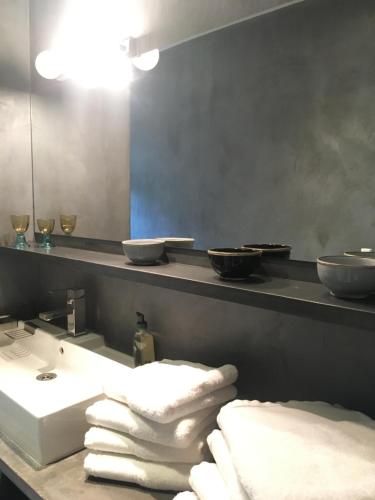 une salle de bain avec un lavabo, un miroir et des serviettes dans l'établissement Cabane de la leque, à Fontvieille
