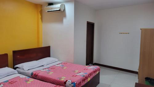 a bedroom with two beds and a light on the wall at PHAPPY GUEST HOUSe in Phnom Penh