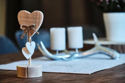 a wooden heart ornament on a table with candles at Ferienhaus Streif LXL in Kirchdorf in Tirol