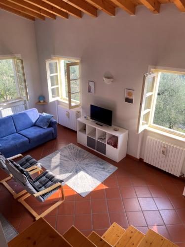 a living room with a blue couch and a tv at Appartamento Cristol in Gargnano