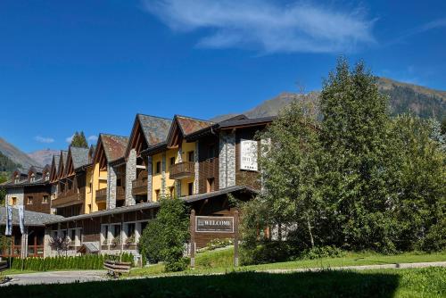 a large building with a sign in front of it at Blu Hotel Acquaseria in Ponte di Legno