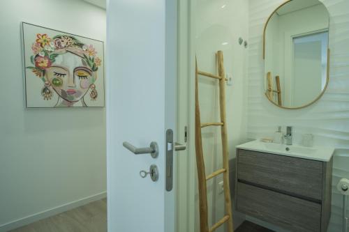 uma casa de banho com um lavatório e um espelho em Casa Mil Verões em Nazaré