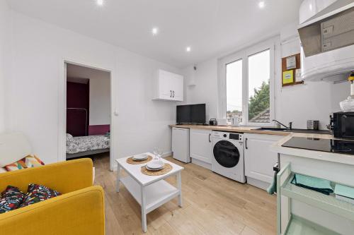 une cuisine et un salon avec un canapé et une table dans l'établissement L'Etape Relax, à Saint-Étienne-du-Rouvray