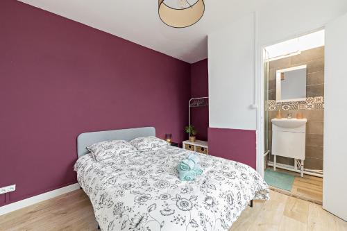 a bedroom with a purple wall and a bed at L'Etape Relax in Saint-Étienne-du-Rouvray