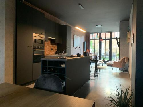 a kitchen with black cabinets and a table in a room at loftlivinq@sea in Middelkerke