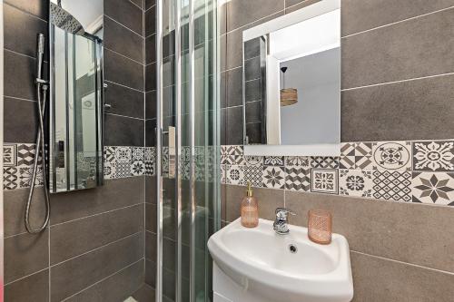 a bathroom with a sink and a shower and a mirror at L'Etape Relax in Saint-Étienne-du-Rouvray