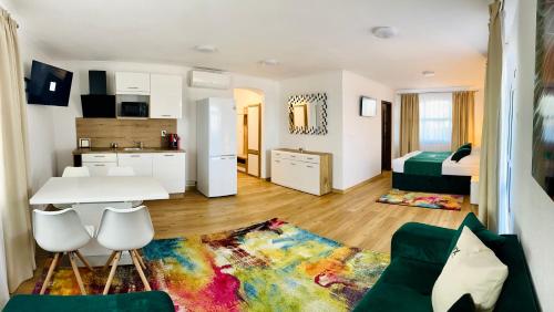 a living room with a white table and a kitchen at WX Hotel in Bratislava