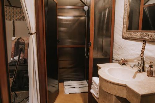 La salle de bains est pourvue d'un lavabo et d'une douche. dans l'établissement Moonlight Desert Camp, à Merzouga