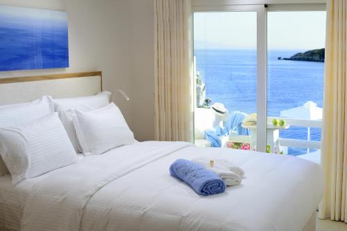 a bedroom with a bed with a view of the ocean at Nissaki Boutique Hotel in Platis Yialos Mykonos