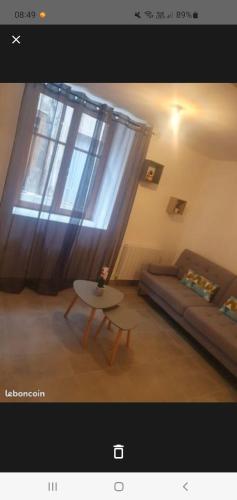 uma sala de estar com um sofá, uma mesa e uma janela em Jolie T2 en rez de chaussée em Carcassonne