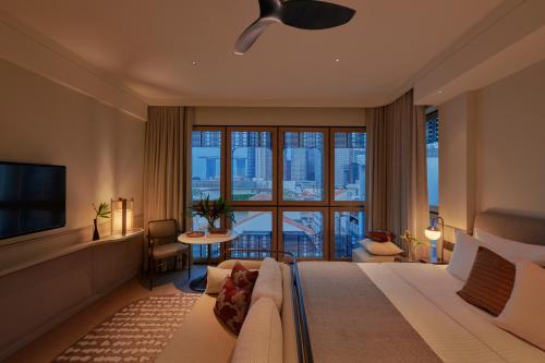 シンガポールにある21 Carpenter, Singapore, a Member of Design Hotelsのベッドと大きな窓があるホテルの部屋