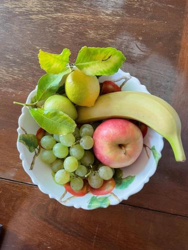 a bowl of fruit with a banana apples and grapes at Appartamento Cristol in Gargnano