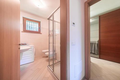 un bagno con wc e porta a vetri di ApartmentsGarda - Corte Sant'Andrea a Lazise